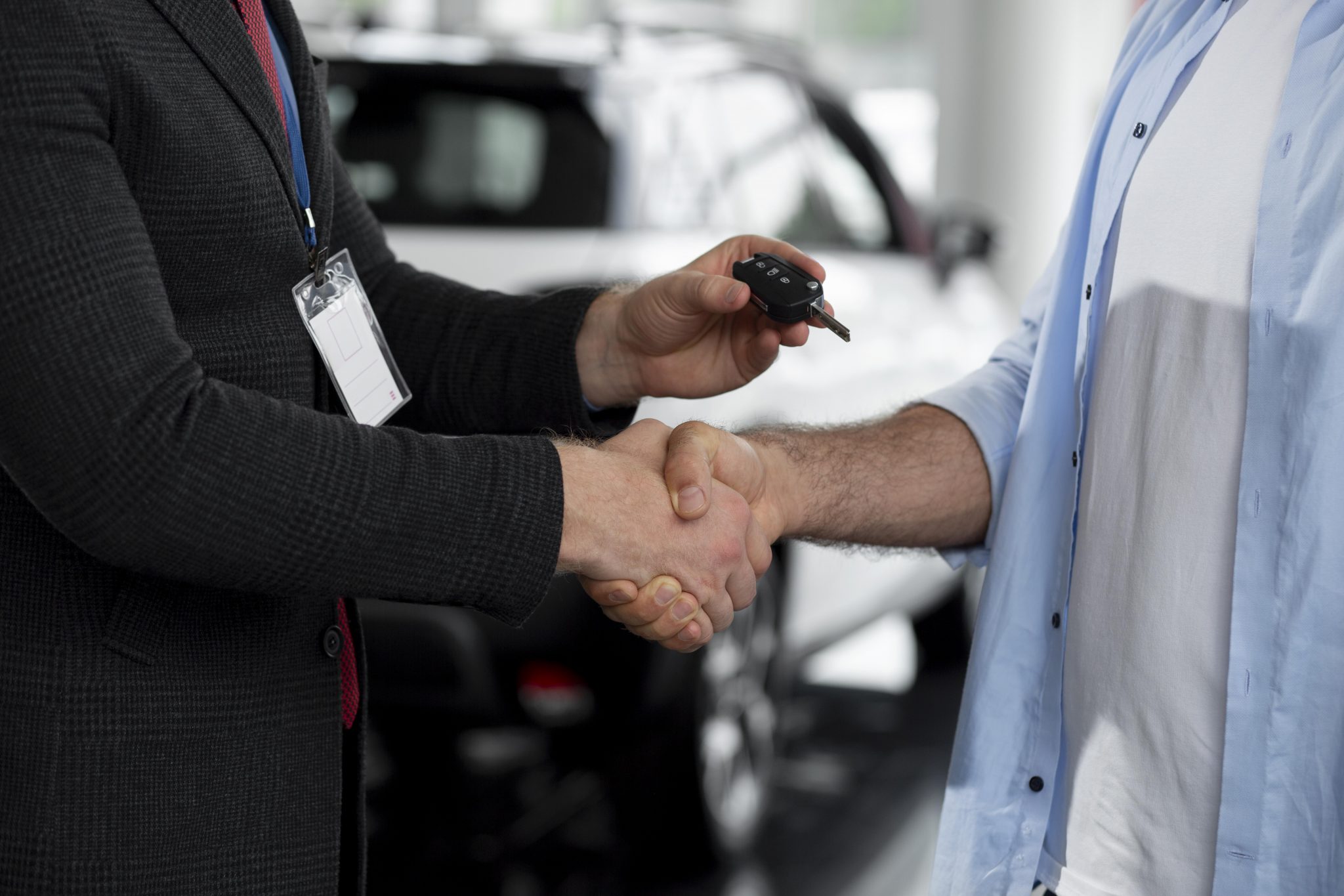 close-up-customer-with-business-person-car-dealership-1-2048x1365.jpg